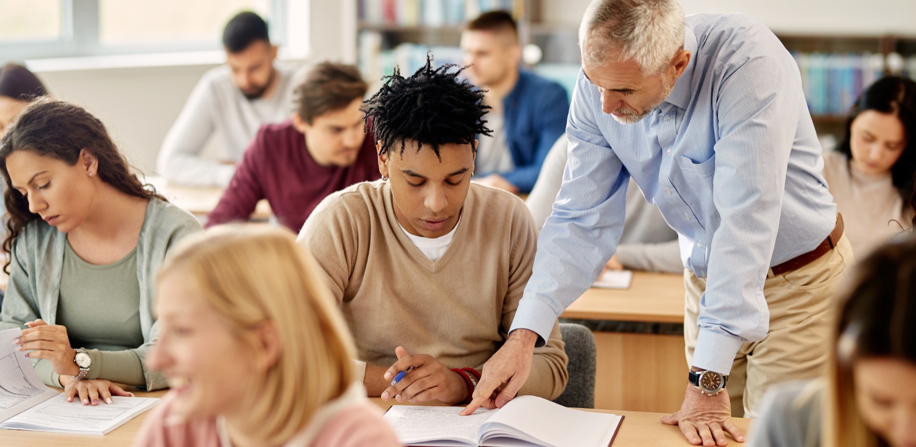 An instructor working with students in a classroom