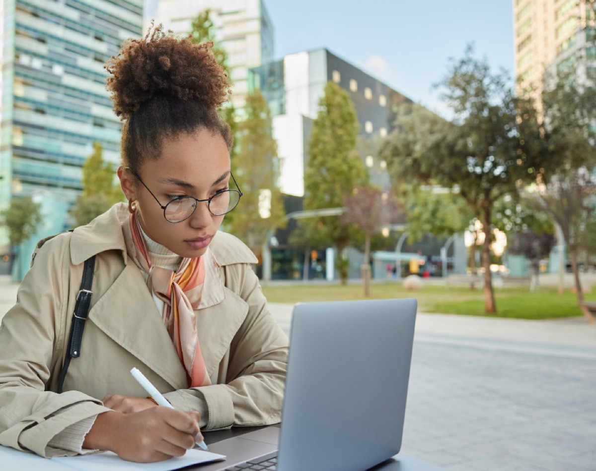 A student studying with a laptop outdoors