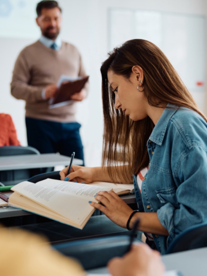 Una estudiante leyendo en un aula